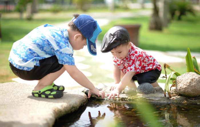 kids playing outside by a pond